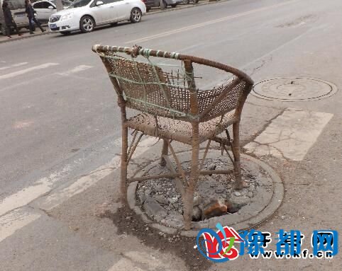 窨井盖破损存在隐患 用破藤椅警示路人 有损城市形象